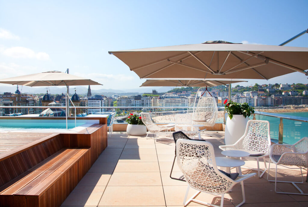 Terraza amplia con mesas y sombrilla con piscina